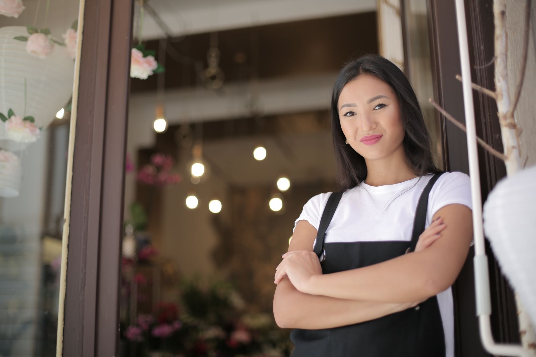 Confident local business owner standing at the entrance of her shop